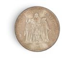 an old coin with a statue on it on a white surface