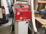a machine that is sitting in a garage next to a van