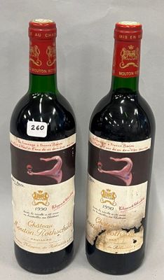 two bottles of red wine sitting next to each other on a table