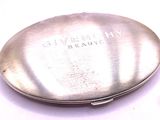 a silver pill case with the word givenchy on it