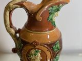 a brown and green vase sitting on a glass table