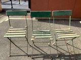three chairs that are sitting on the sidewalk