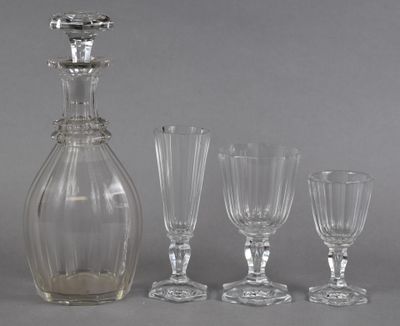 four wine glasses and a decanter sitting next to each other