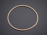 a gold rope bracelet on a black background