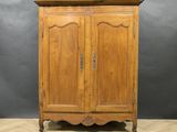 une armoire en bois à deux portes, surmontée d'un tiroir