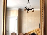 a large mirror in the middle of a room with chairs