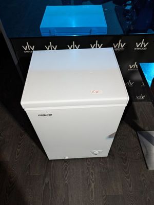 une petite boîte blanche posée par terre à côté d'un téléviseur