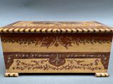 an old wooden box with a decorative design on the lid