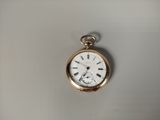 a gold pocket watch with roman numerals on it