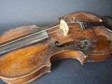 an old violin sitting on top of a wooden table