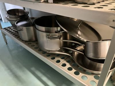 de nombreuses casseroles et poêles sur l'étagère de la cuisine