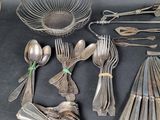 a lot of silver spoons and forks on the table
