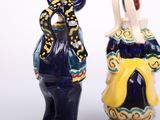 two figurines of people standing next to each other