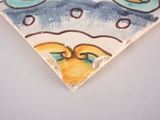 a close up of a tile with a bird on it