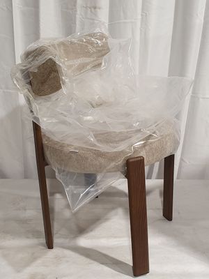 a plastic chair wrapped in plastic and sitting on a white surface