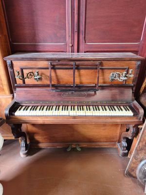 un piano qui se trouve dans le coin d'une pièce