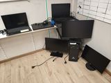 three computers and two laptops sitting on a desk