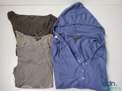 two shirts with hoodies sitting on top of each other on a table