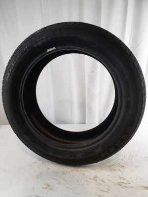 a close up of a tire on a white surface with a curtain in the background