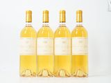 quatre bouteilles de vin sont alignées sur une surface blanche