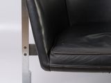 a black leather chair with a metal frame on a white background