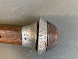 a wooden stick with a metal handle on a table