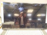 a man taking a picture of a broken screen in a store