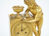 a gold clock with a statue on top of it