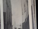 a black and white photo of a street with a boat on it