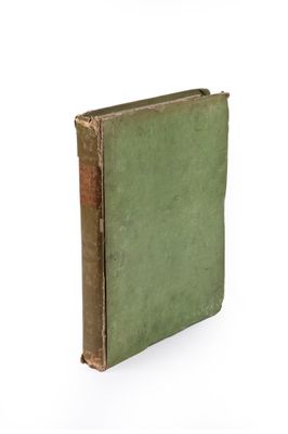un vieux livre à la couverture verte posé sur une surface blanche