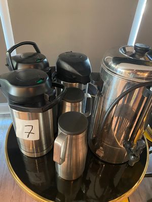 many coffee pots and cups sitting on a table