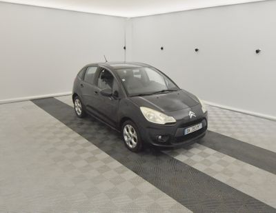 une photo d'une petite voiture noire dans un garage
