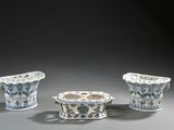 trois vases bleus et blancs ornés de motifs, posés sur une table