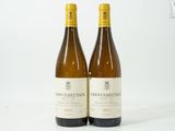 deux bouteilles de vin posées l'une à côté de l'autre sur une surface blanche
