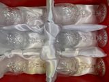 six verres à vin vides dans une boîte rouge ornée d'un ruban