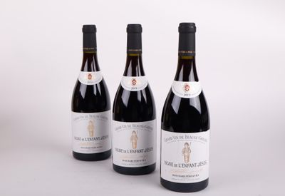 three bottles of wine are lined up on a white surface