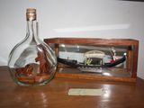 a glass bottle with a ship inside of it on a table