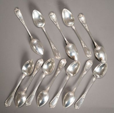 Plusieurs cuillères en argent et cuillères-cuillères sont disposées en cercle
