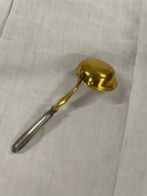 une cuillère en or posée sur une nappe blanche