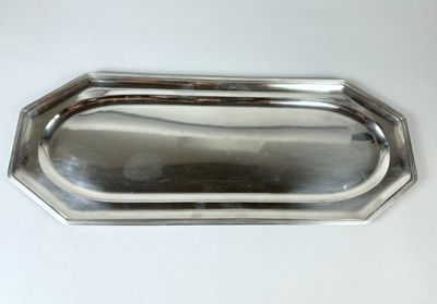 an image of a silver tray with a handle on a white table