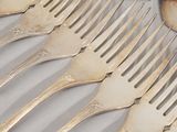 a lot of forks and spoons that are on a table