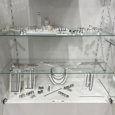 a glass display case with many different jewelry items on it