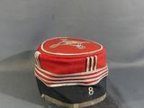 a red and black hat sitting on top of a gray table