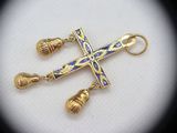 a close up of a cross with bells on a white surface