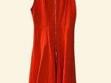 a red dress hanging on a hanger on a white wall