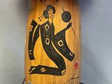 a wooden table with a lamp on it and a painting on it