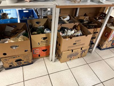 de nombreuses boîtes remplies d'affaires par terre dans la cuisine