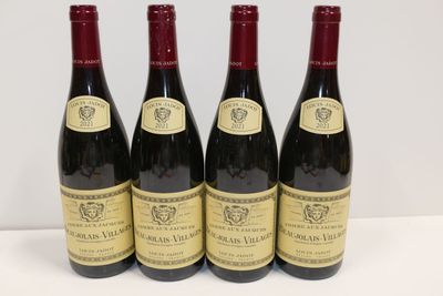 quatre bouteilles de vin sont alignées sur une table