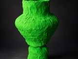 un vase vert posé sur une surface noire