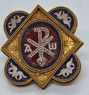 une image représentant une broche bleue et dorée ornée d'une croix